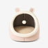 Maison douillette pour chat rose en studio vu de face, forme cocon avec coussin intérieur et pompon.