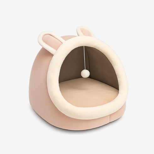 Maison douillette pour chat rose en studio, forme cocon avec coussin intérieur moelleux.