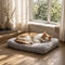 Chat allongé sur un matelas pour chat gris en peluche douce, couchage moelleux et confortable près d’une fenêtre lumineuse.