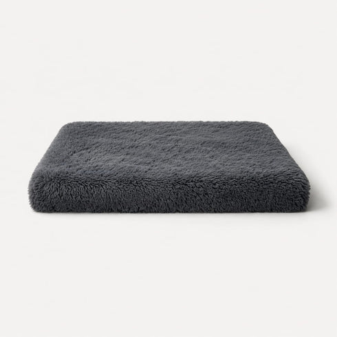 Matelas pour chat gris foncé en peluche douce avec rembourrage épais, couchage confortable et design sur fond studio épuré.