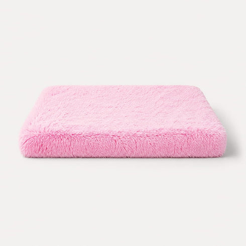 Matelas pour chat rose en peluche douce avec rembourrage épais, couchage confortable et design sur fond studio épuré.