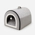 Petite niche pour chat grise avec coussin moelleux et entrée en peluche blanche, idéale pour offrir un coin repos confortable au chat.
