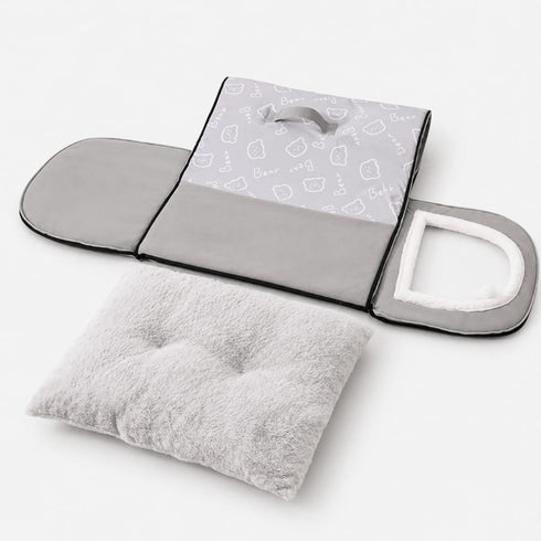 Petite niche pour chat pliable grise présentée à plat avec coussin moelleux amovible et structure zippée facile à transporter.