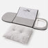 Petite niche pour chat pliable grise présentée à plat avec coussin moelleux amovible et structure zippée facile à transporter.