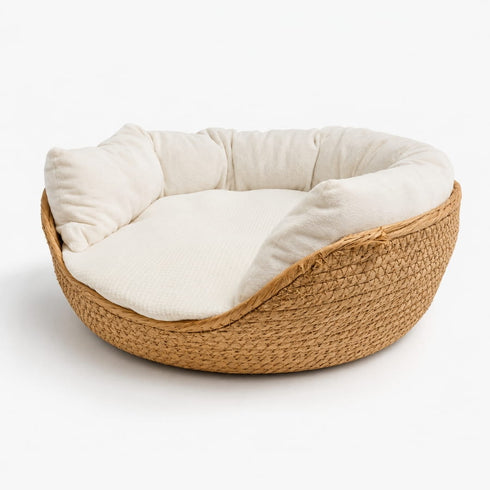 Niche en osier pour chat en imitation osier avec coussin blanc épais et rebords moelleux, présentée sur fond neutre gris clair.