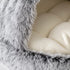 Gros plan sur la texture en peluche grise ultra douce et le coussin moelleux d’un nid pour chat, conçu pour un confort chaleureux et apaisant.