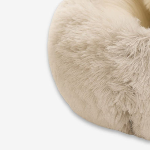 Zoom sur la texture en fausse fourrure beige du nid pour chat, détail du rebord doux.