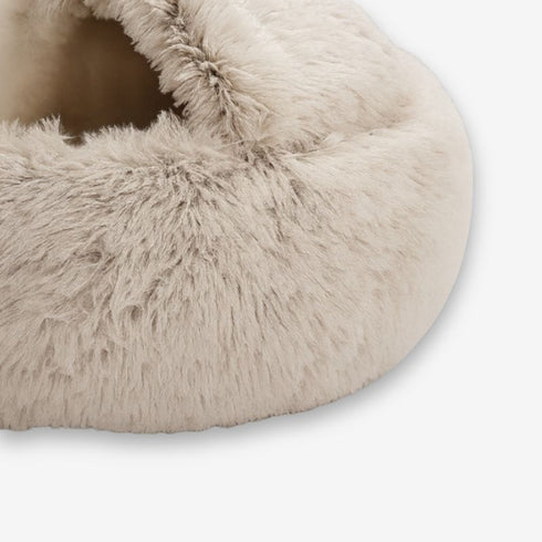 Gros plan sur la texture en fausse fourrure beige du nid pour chat, montrant les détails doux et moelleux du tissu.