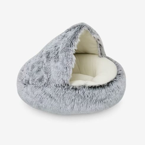 Nid pour chat en fausse fourrure grise avec intérieur crème, couchage douillet en forme d’abri.