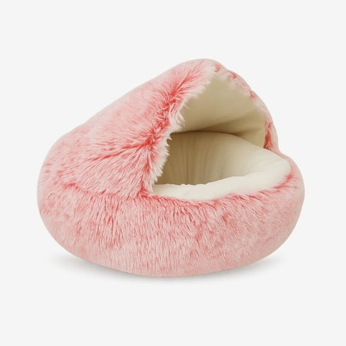 Nid pour chat rose en fausse fourrure avec large ouverture et intérieur crème, couchage douillet cocooning.