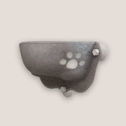 Panier de fenêtre pour chat en tissu feutré gris, avec motif patte ajourée et fixation par ventouses, présenté seul en studio sur fond clair.