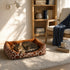 Chat allonge dans un panier chat xxl avec motifs marron style savane et rebords rembourres, installe dans un salon lumineux et cosy
