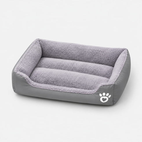 Panier chauffant pour chat gris avec rebords rembourrés et surface douce, idéal pour offrir un couchage chaud et confortable.