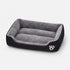 Panier chauffant pour chat noir et gris avec rebords rembourrés et surface douce, idéal pour offrir un couchage chaud et confortable.