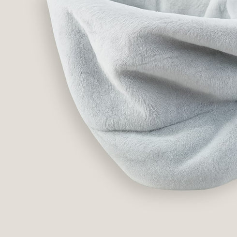 Gros plan du tissu doux et moelleux du panier radiateur pour chat gris clair.