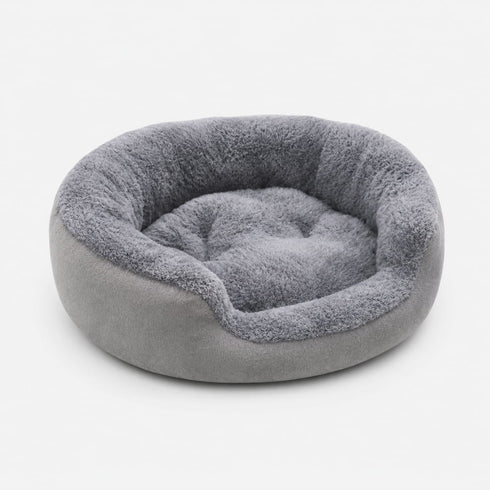 Panier rond pour chat gris clair en peluche ultra douce avec coussin moelleux et rebords épais pour un repos confortable.