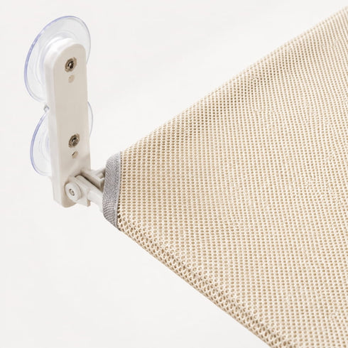 Gros plan sur le tissu en maille beige et la fixation à ventouses d’un perchoir de fenêtre confortable pour chat d’intérieur.