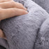 Zoom sur la texture douce du petit coussin pour chat en peluche gris clair, compressé à la main.
