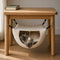 Petit hamac suspendu pour chat fixé sous une table en bois, avec chat confortablement installé dans une niche suspendue douce et cocooning pour intérieur chaleureux.