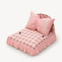 Petit lit pour chat rose à carreaux avec coussin décoratif et finitions dentelle, présenté sur fond clair en vue studio.
