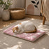 Petit tapis pour chat rose et blanc avec motifs doux, utilisé par un chat blanc et roux dans un intérieur chaleureux et apaisant