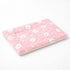 Petit tapis pour chat rose matelassé avec motifs têtes de chat et texture douce sur fond studio clair et minimaliste