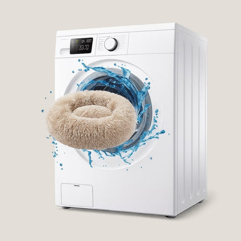 Pouf pour chat beige lavable en machine, illustré devant un tambour en mouvement avec des éclaboussures d’eau.