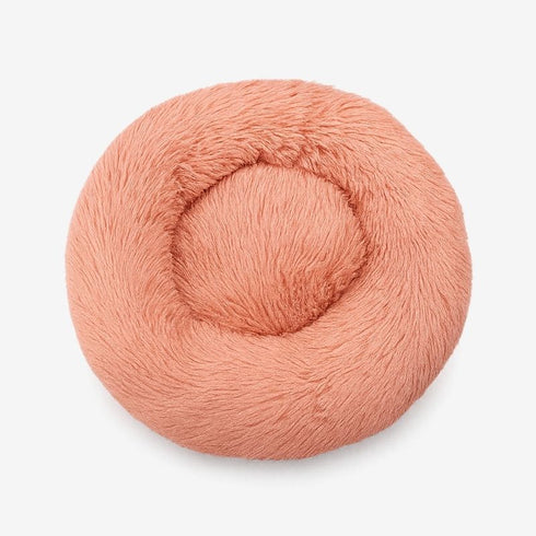Pouf pour chat rose corail en fausse fourrure, photographié directement de dessus.
