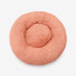Pouf pour chat rose corail en fausse fourrure, photographié directement de dessus.