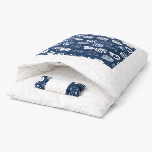 Sac de couchage pour chat blanc avec motifs bleus, coussin intégré et ouverture enveloppante pour un couchage chaud et confortable.