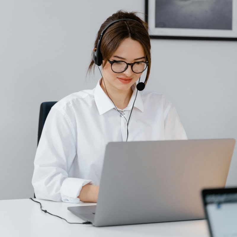 Conseillère support CatNest avec casque, devant un ordinateur portable au bureau