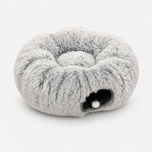 Tanière pour chat grise en peluche avec tunnel intégré et pompon suspendu, présentée sur fond clair en photo produit