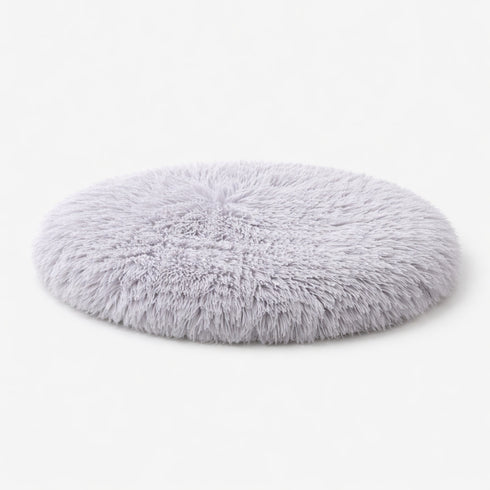 Tapis apaisant rond pour chat en peluche grise clair ultra douce sur fond studio clair avec rembourrage moelleux et confortable