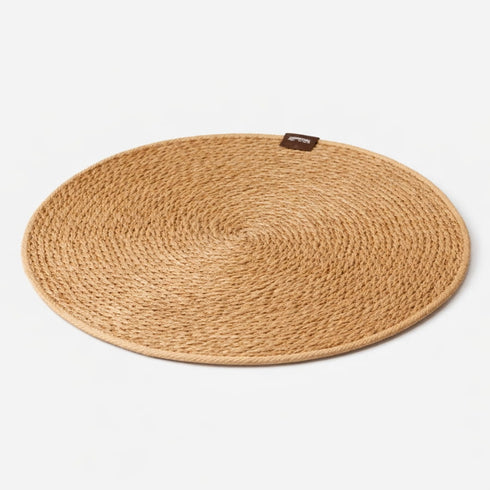 Tapis griffoir rond pour chat en fibres naturelles tressées sur fond studio clair avec design minimaliste et texture résistante
