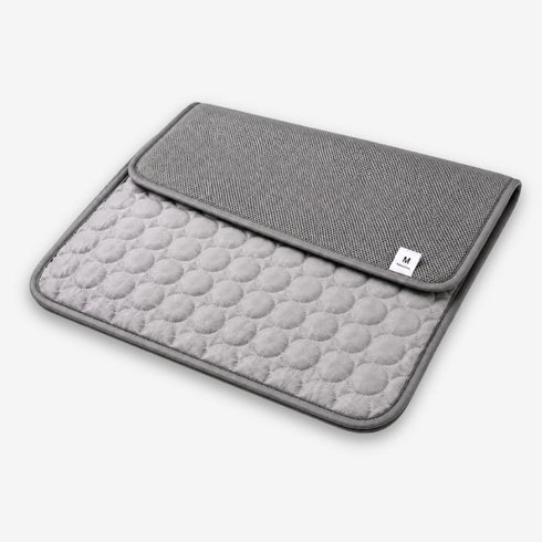Tapis rafraîchissant pour chat gris plié en deux, mettant en valeur ses deux faces, sa texture respirante et son format pratique pour un confort optimal.
