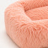 Gros plan sur la texture ultra douce et moelleuse d’un coussin apaisant rose pour chat, avec fibres longues et effet cocooning.